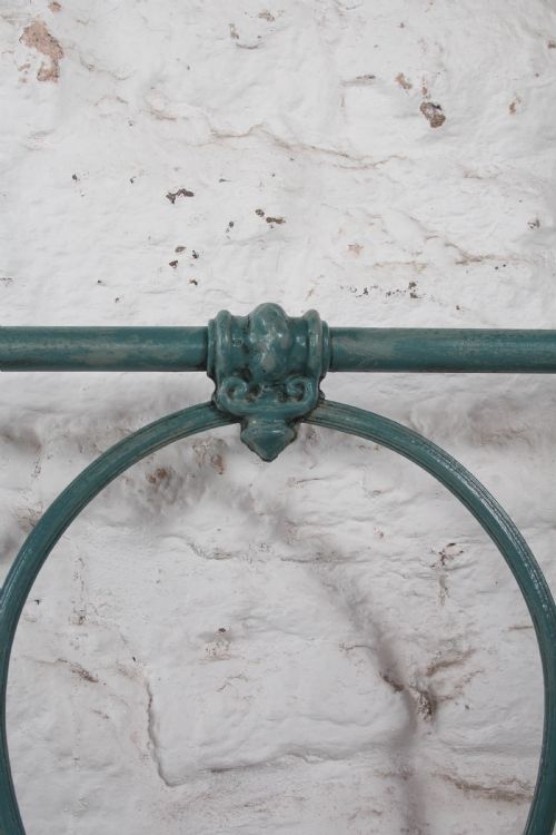 fig 4. A pair of green painted iron single bed frames featuring scrolled Celtic heart motifs on the headboards and low open ends.