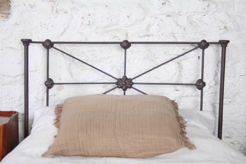 fig 2. A pair of dark Victorian wrought iron single beds with geometric headboards and footless frames.