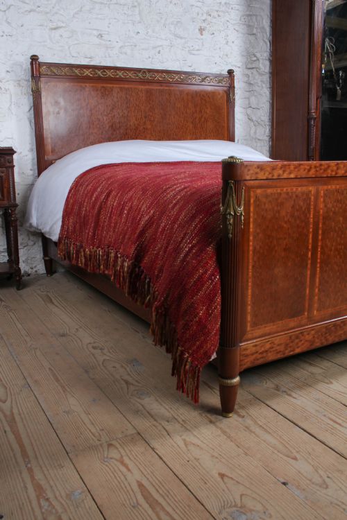 fig 1. An antique French mahogany king-size bed frame featuring inlaid wood borders, decorative brass mounts, and fluted corner posts.