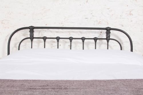 fig 2. A Victorian Art Nouveau style black cast iron king size bed frame featuring vertical spindles and decorative joinery details.
