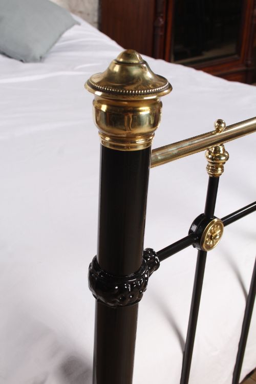 fig 3. A Victorian black cast iron double bed frame with brass top rails, brass finials, and mother-of-pearl inlay details.