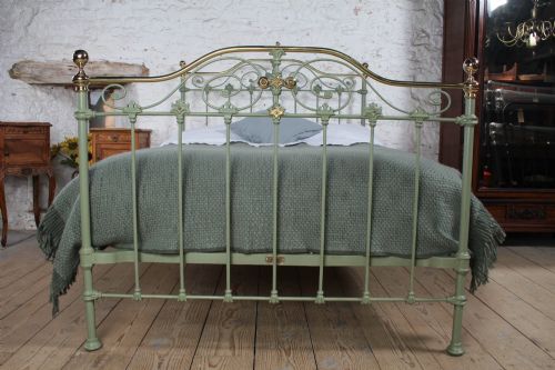 fig 1. A Victorian sage green painted iron double bedstead featuring decorative scrollwork and polished brass top rails with spherical finials.