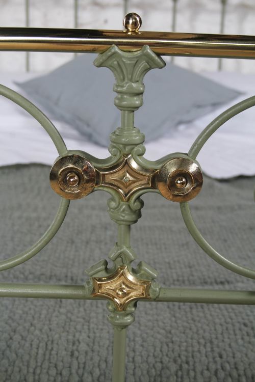fig 2. A Victorian sage green painted iron double bedstead featuring decorative scrollwork and polished brass top rails with spherical finials.