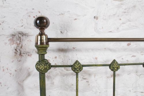 fig 1. A king-size Victorian green painted iron bed frame featuring decorative central castings, vertical spindles, and a brass top rail with finials.