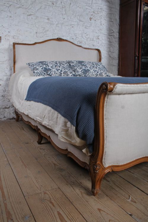 fig 4. A Louis XV style king-size bed frame featuring a carved wooden structure, cabriole feet, and neutral upholstered headboard and footboard panels.