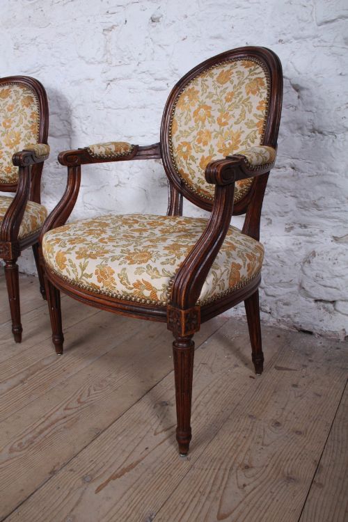 fig 1. A pair of Louis XVI style carved timber armchairs with oval medallion backs and floral patterned upholstery.