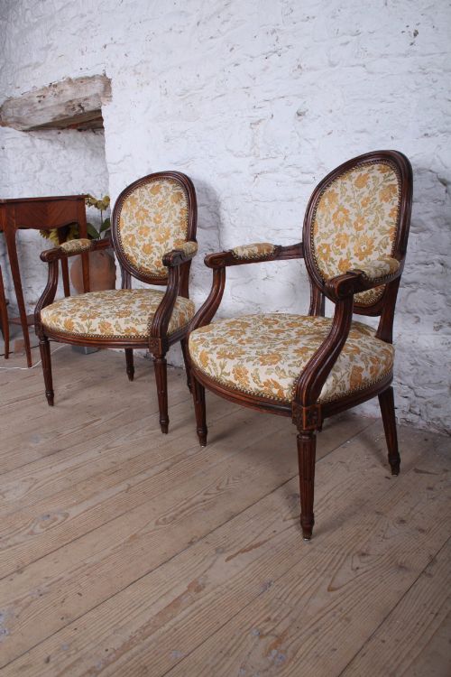 fig 2. A pair of Louis XVI style carved timber armchairs with oval medallion backs and floral patterned upholstery.