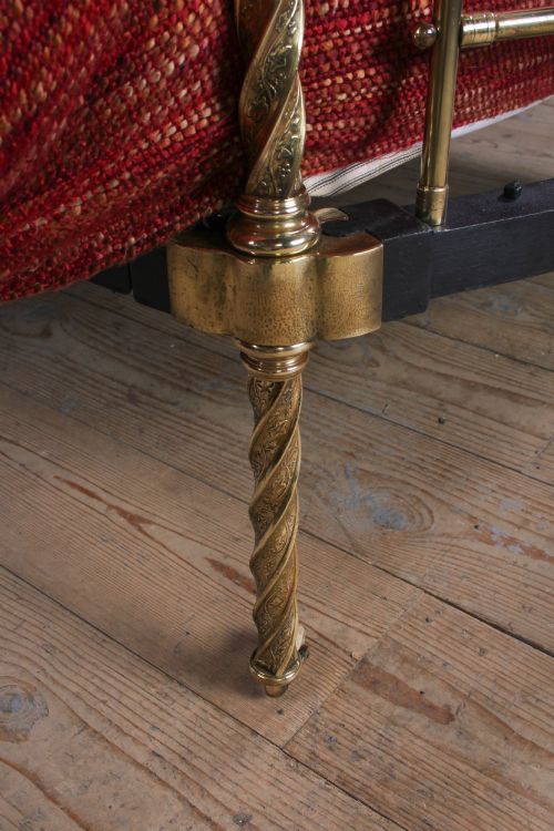 fig 3. A Victorian iron and brass king-size bedstead featuring barley twist posts, ornate brass scrollwork on the footboard, and a arched black iron headboard.