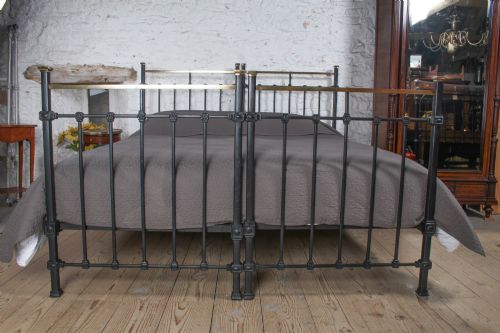 fig 4. A pair of Edwardian black iron single beds featuring square tube framing, vertical spindles, and polished brass top rails.