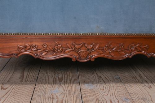 fig 2. A French Provincial style single bed featuring a carved timber frame with blue velvet upholstered headboard and footboard panels.