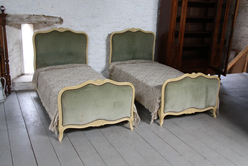 Pair of French upholstered single beds with crackle aged old white paintwork