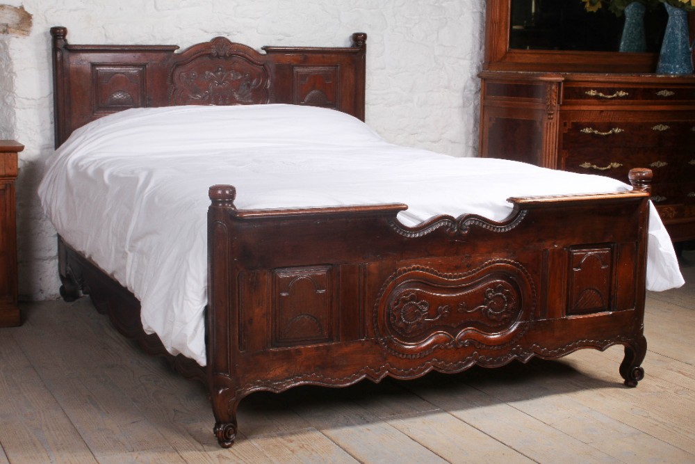 Lovely solid carved dark cherry Provencale king size bed with shaped  panels and foliate carving.