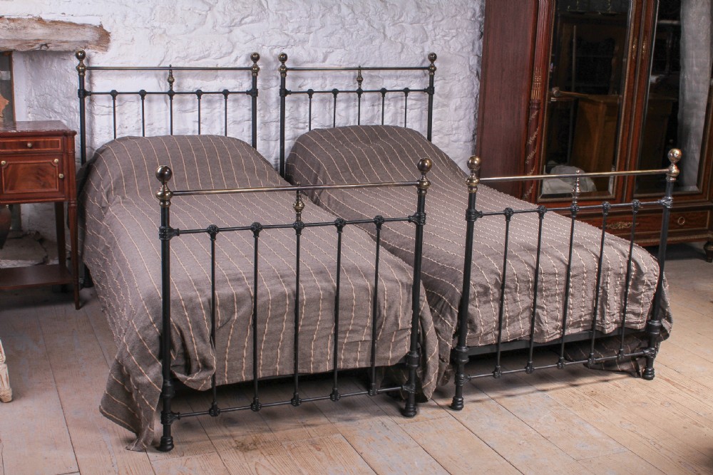 Lovely pair of black and aged brass single beds