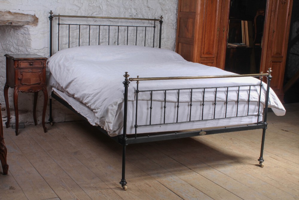 Pleasingly simple early Victorian brass and iron king size bed with forged iron panel