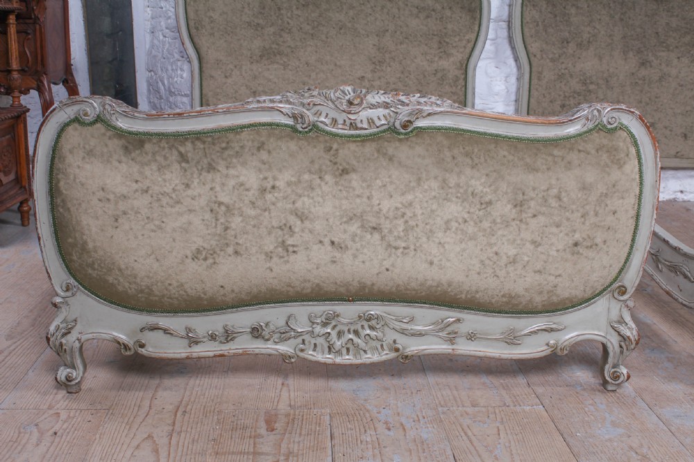 A pair of French Louis XV style single bed frames with carved grey painted timber and olive green velvet upholstered panels. View II