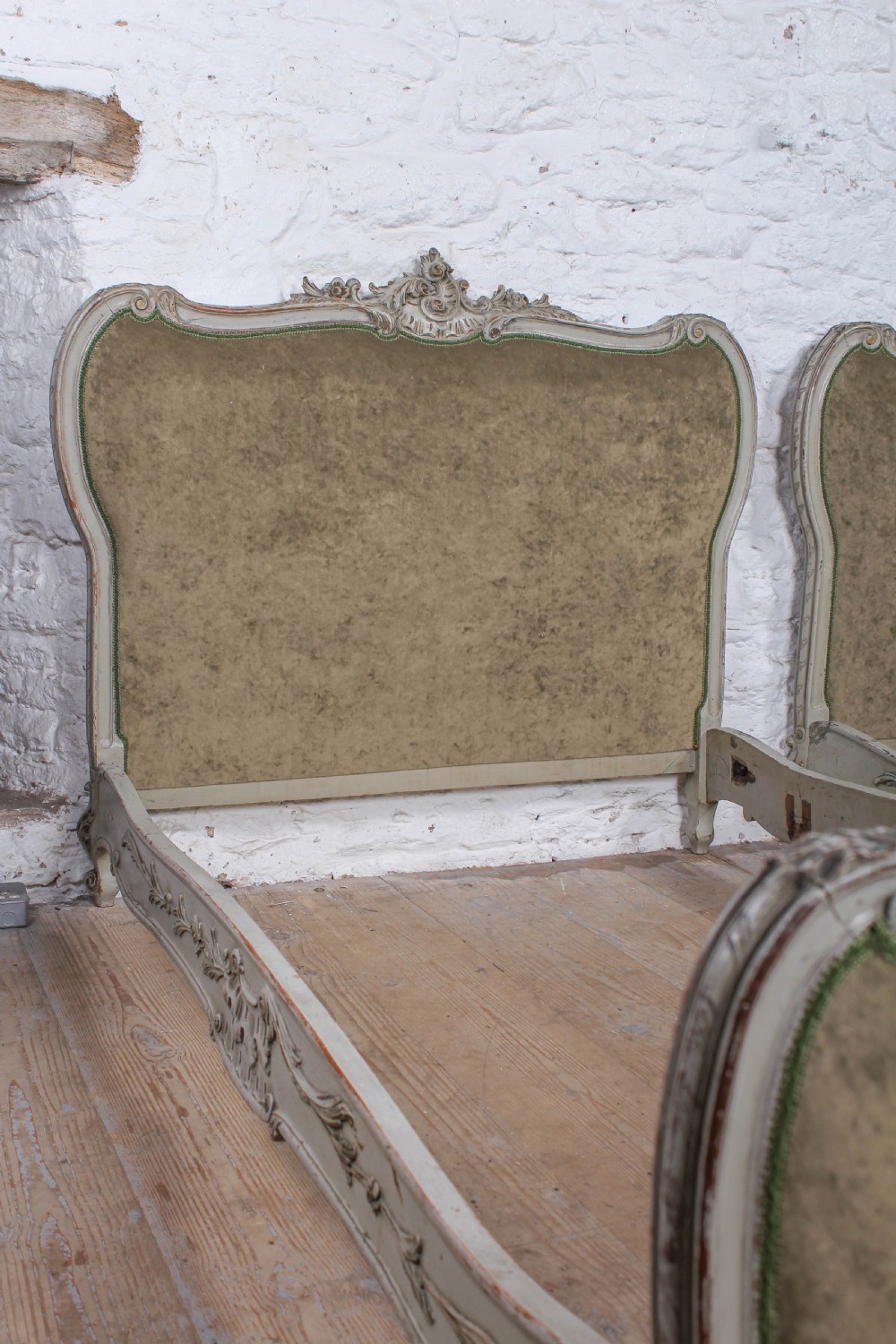 A pair of French Louis XV style single bed frames with carved grey painted timber and olive green velvet upholstered panels. View VII