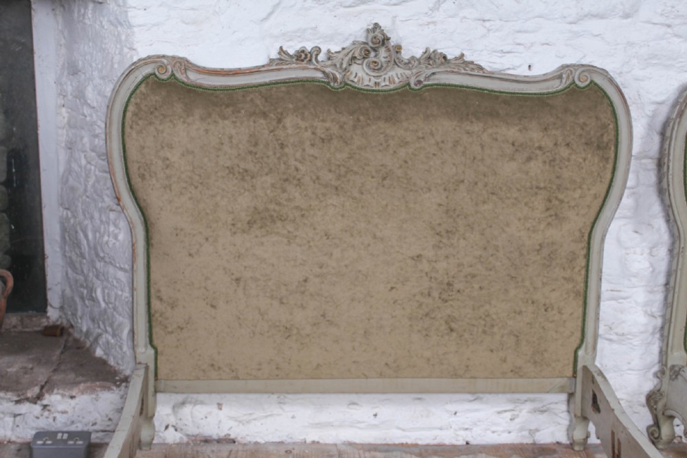 A pair of French Louis XV style single bed frames with carved grey painted timber and olive green velvet upholstered panels. View VIII