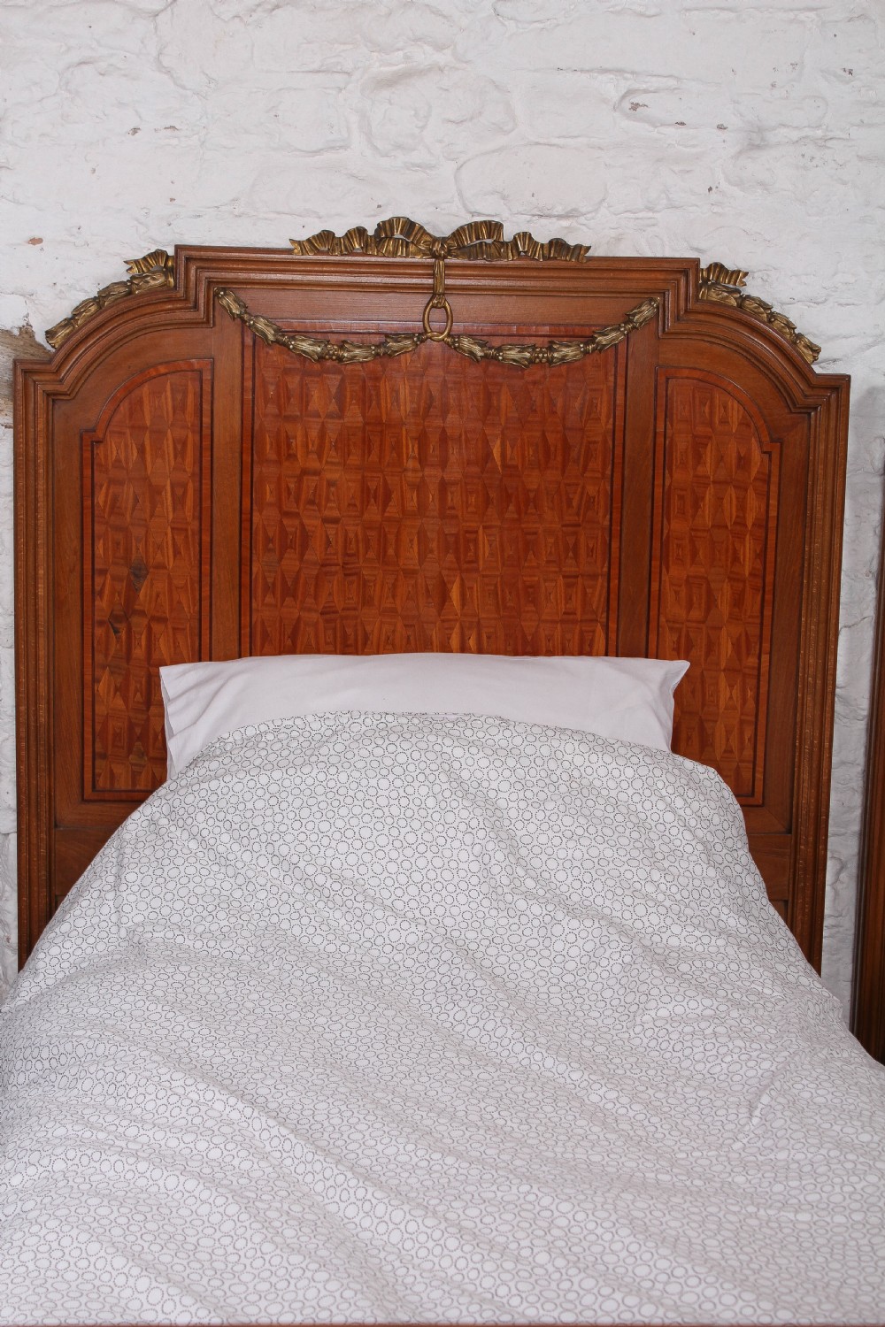 A pair of antique French fruitwood single beds featuring geometric parquetry inlay and decorative gilt bronze mounts on the headboards and footboards. View III