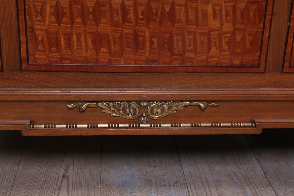A pair of antique French fruitwood single beds featuring geometric parquetry inlay and decorative gilt bronze mounts on the headboards and footboards. View VII
