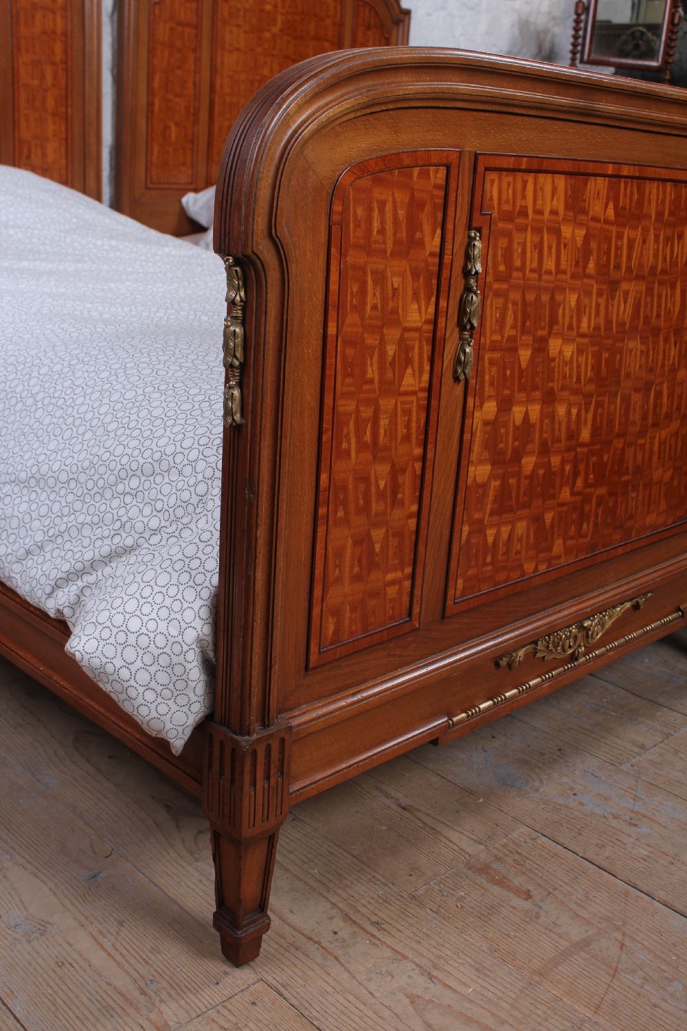 A pair of antique French fruitwood single beds featuring geometric parquetry inlay and decorative gilt bronze mounts on the headboards and footboards. View VIII