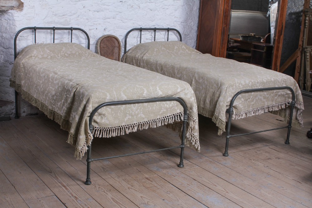 Lovely simple pair of utilitarian single iron beds