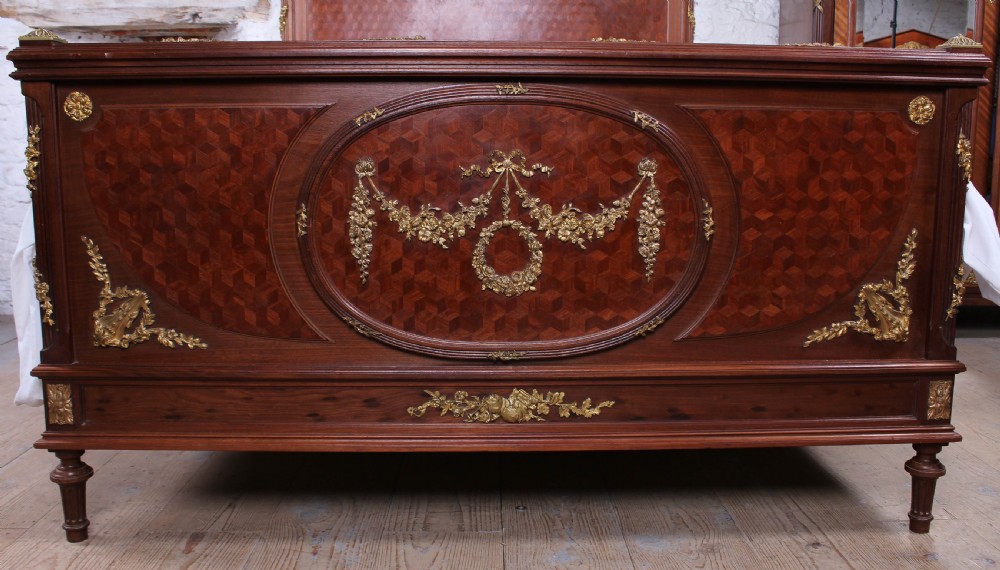 Magnificent mahogany and fruit wood parquetry king size bed with striking ormolu decoration. View II