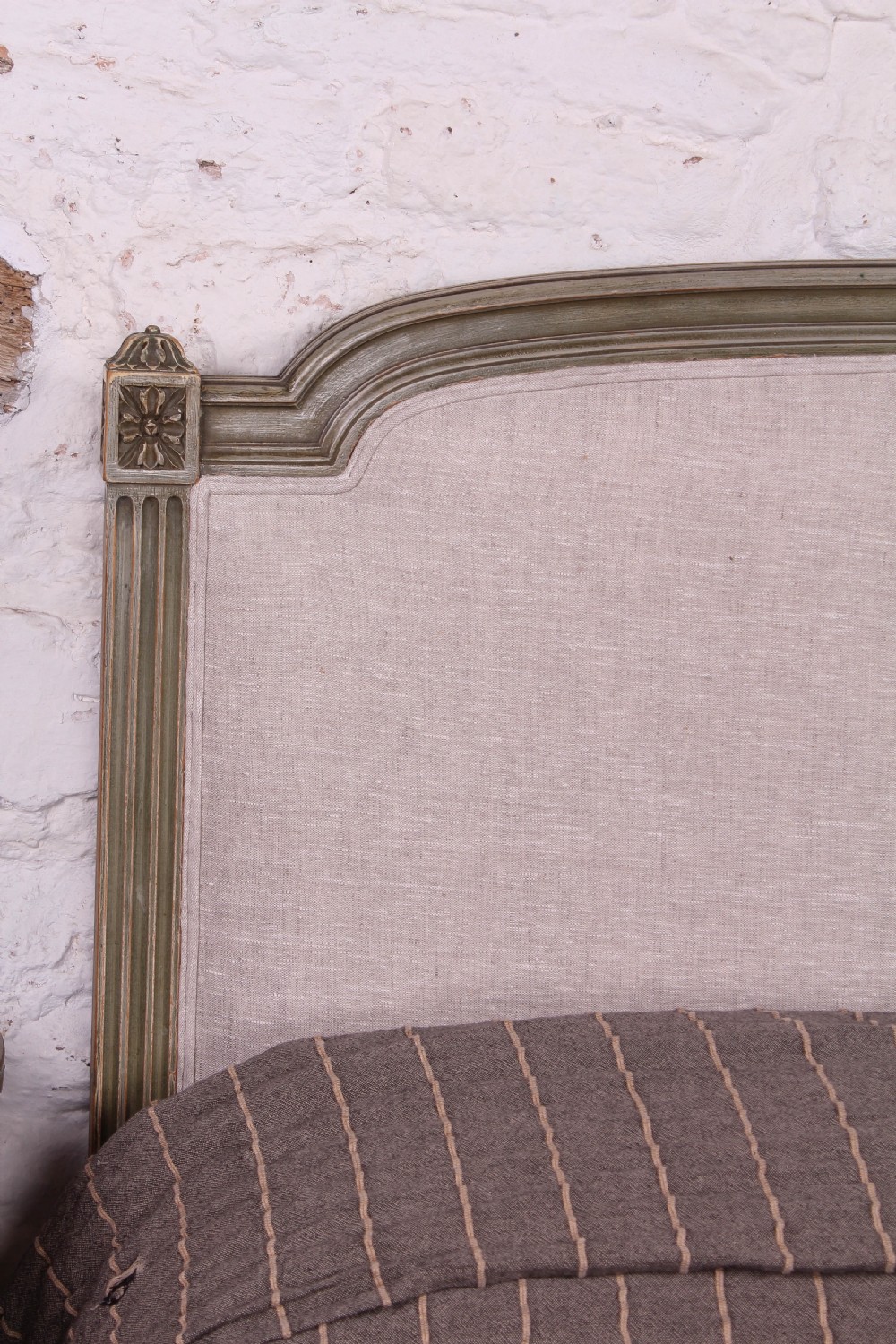 A Louis XVI style French king-size bed frame featuring a muted green painted wooden trim, fluted corner posts, rosettes, and cream linen upholstered panels on the headboard and footboard. View V