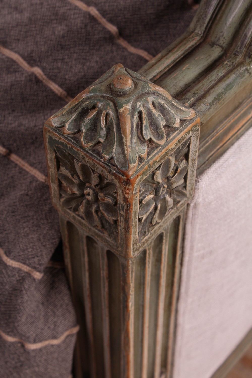 A Louis XVI style French king-size bed frame featuring a muted green painted wooden trim, fluted corner posts, rosettes, and cream linen upholstered panels on the headboard and footboard. View VI