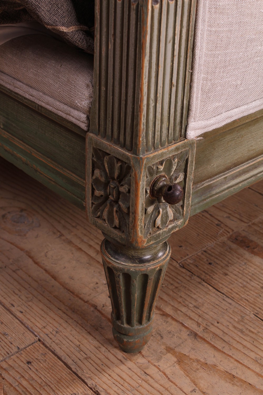 A Louis XVI style French king-size bed frame featuring a muted green painted wooden trim, fluted corner posts, rosettes, and cream linen upholstered panels on the headboard and footboard. View VIII