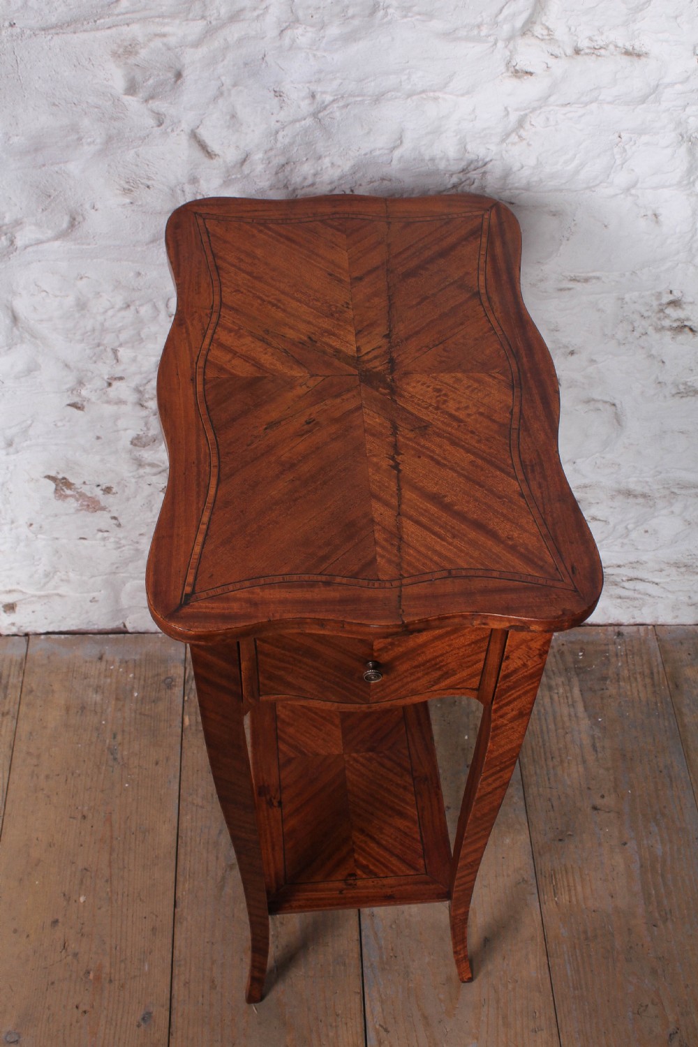 A tall French walnut veneer side table featuring a serpentine top with geometric parquetry inlay, a single front drawer, a lower tier shelf, and slender cabriole legs. View III