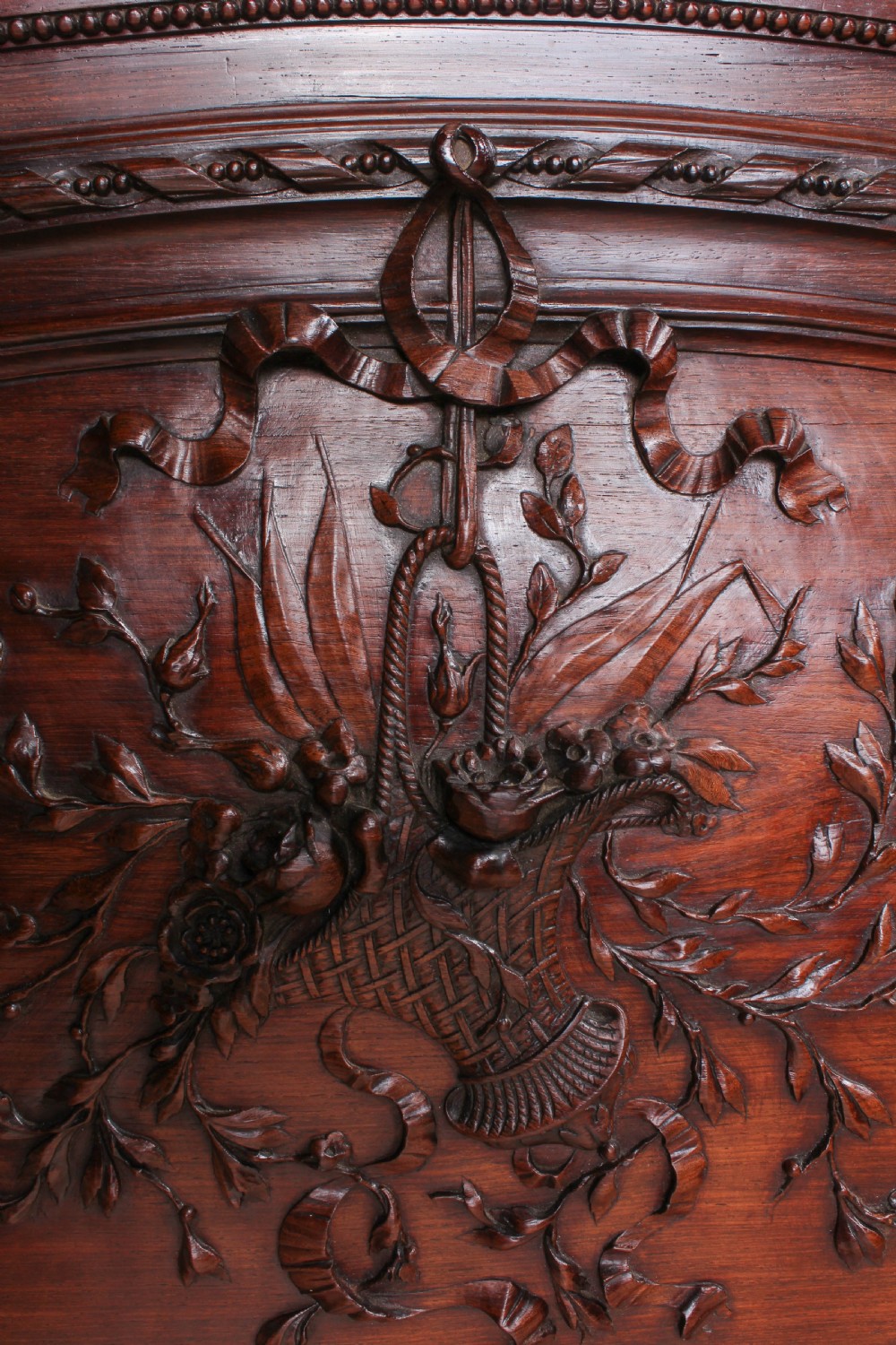 A French rosewood bed frame with a high arched headboard and a carved floral oval cartouche on the footboard. View VIII