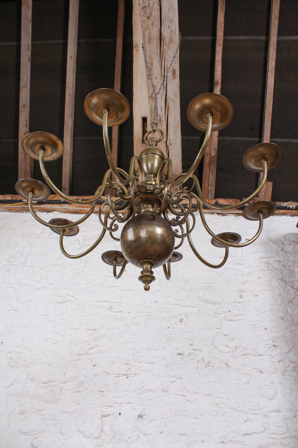 A Flemish style solid brass ceiling chandelier featuring multiple S-scrolled arms attached to a central turned baluster stem with a spherical base terminal. View III