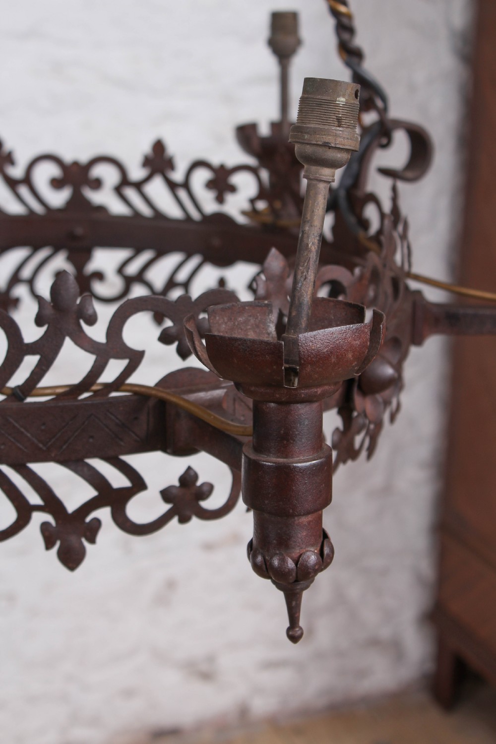 A French wrought iron chandelier with a pierced decorative rim, twisted iron support rods, and sculpted floral details. View II