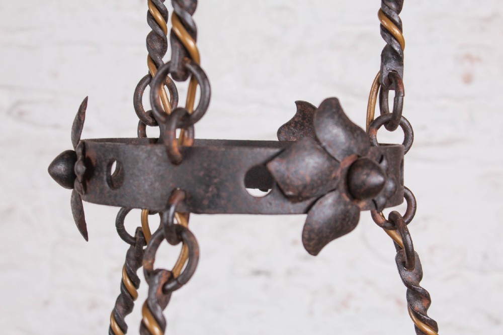 A French wrought iron chandelier with a pierced decorative rim, twisted iron support rods, and sculpted floral details. View IV