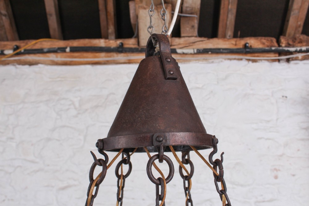 A patinated dark copper Arts and Crafts circular hoop chandelier suspended by four metal chains from a conical top cap. View III