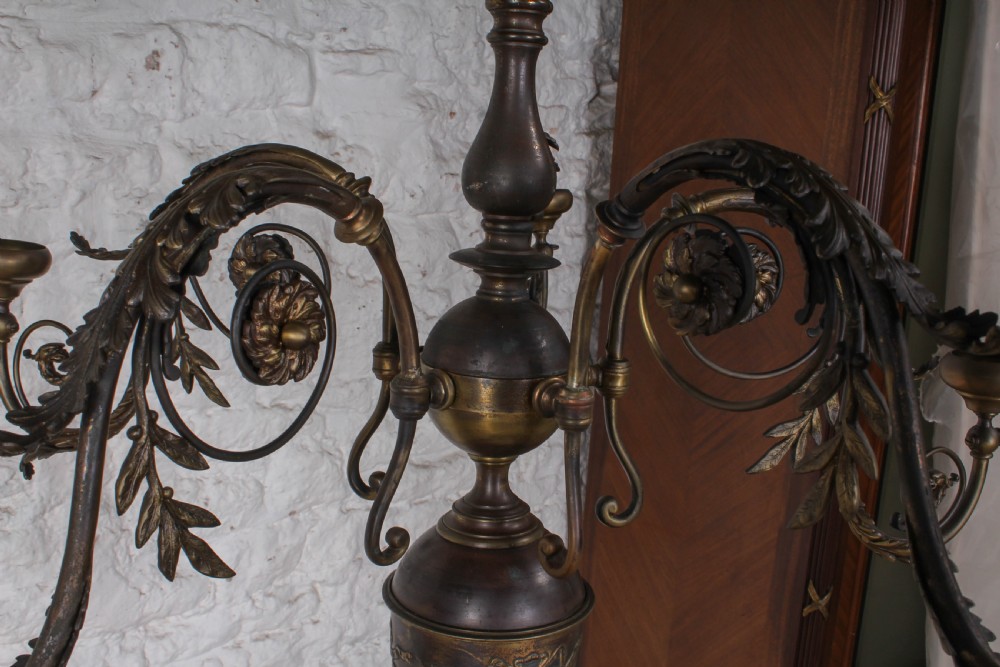 A French cast brass ceiling chandelier featuring scrolled arms, foliate leaves, floral rosettes, and a central turned stem with an urn-shaped lower finial. View IV