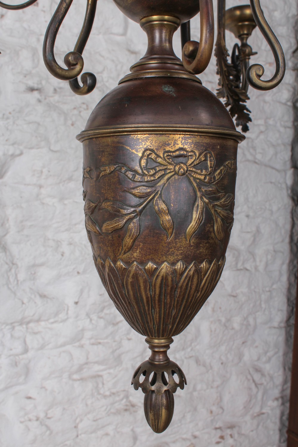 A French cast brass ceiling chandelier featuring scrolled arms, foliate leaves, floral rosettes, and a central turned stem with an urn-shaped lower finial. View V