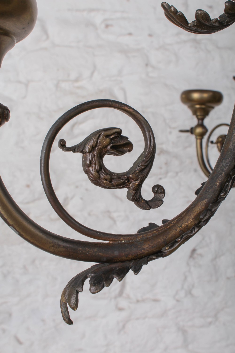 A French cast brass ceiling chandelier featuring scrolled arms, foliate leaves, floral rosettes, and a central turned stem with an urn-shaped lower finial. View VI