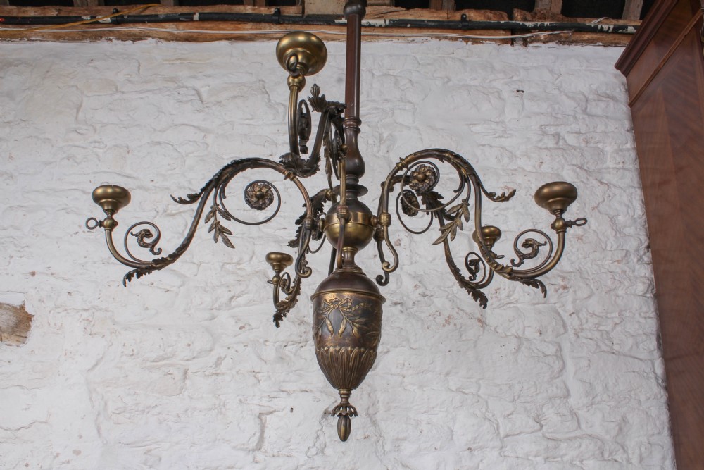 A French cast brass ceiling chandelier featuring scrolled arms, foliate leaves, floral rosettes, and a central turned stem with an urn-shaped lower finial. View VII
