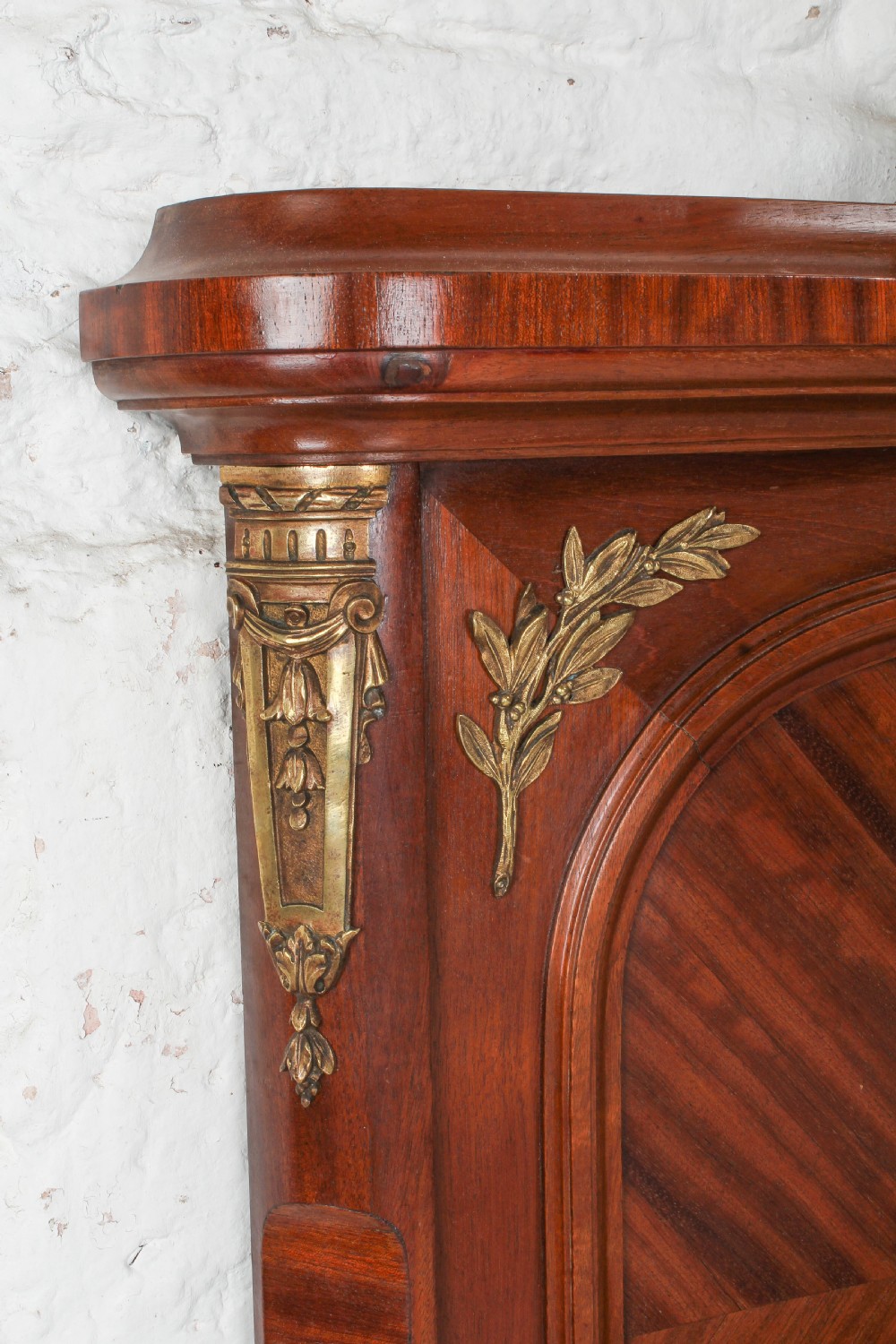 An antique French mahogany bed frame featuring geometric parquetry panels, fruitwood ribbon marquetry on the footboard, and gilt bronze mounts. View VI
