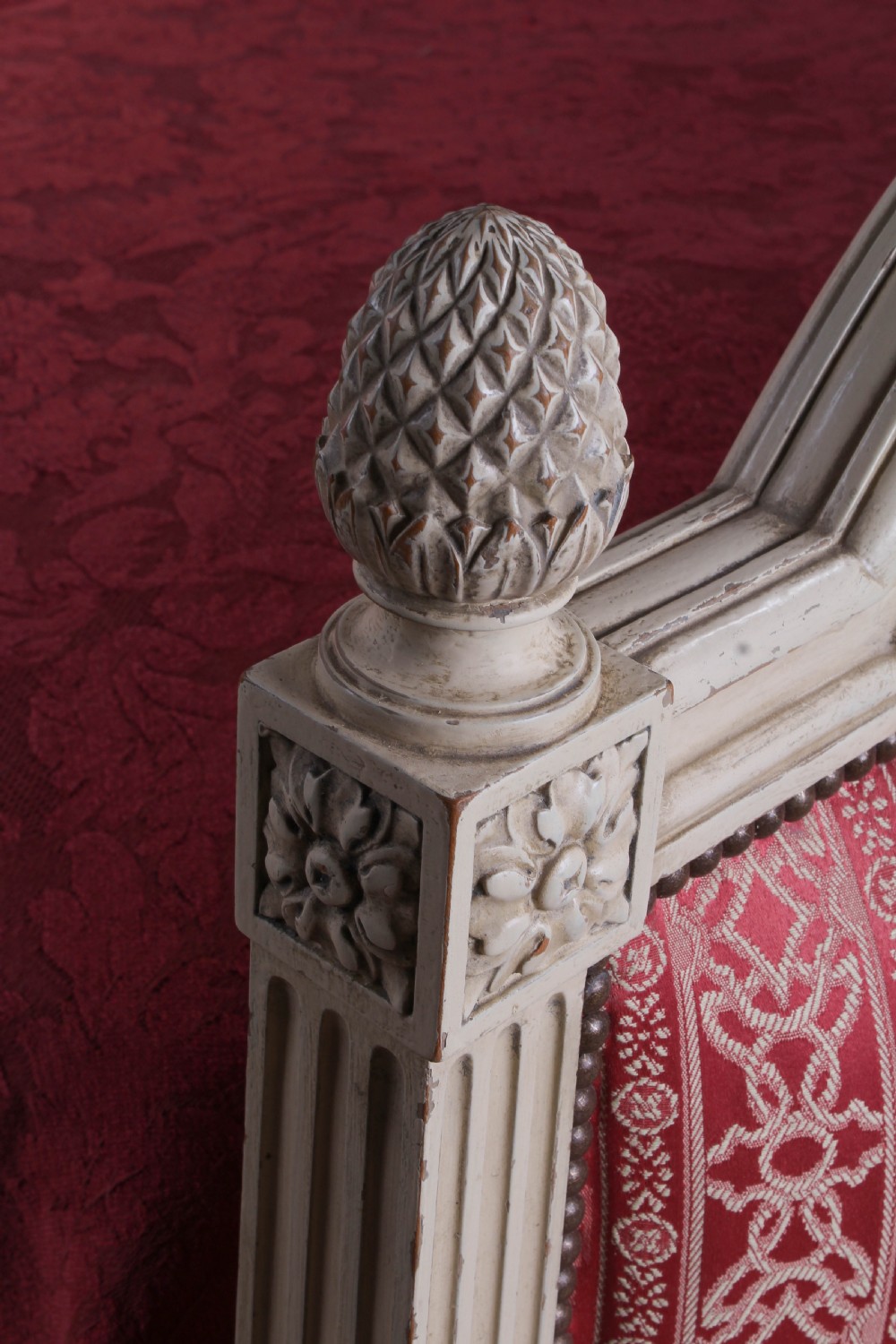 A French Louis XVI style king size bedstead featuring a cream painted carved timber frame and red patterned damask upholstered headboard and footboard. View II