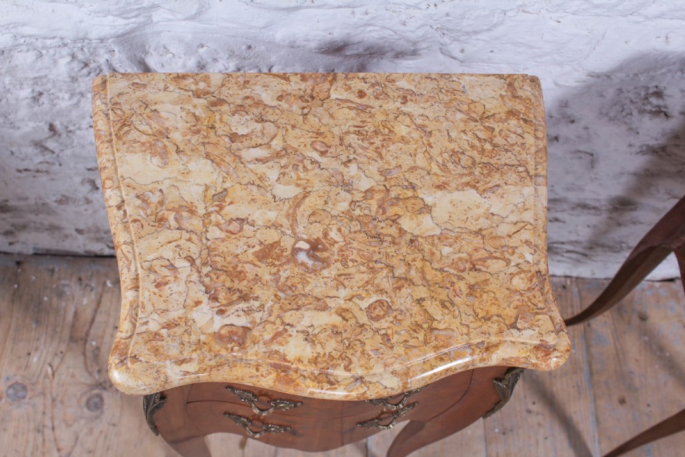 A pair of French Louis XV style bow-front bedside tables featuring floral marquetry inlay, cabriole legs, brass handles, and marble tops. View III