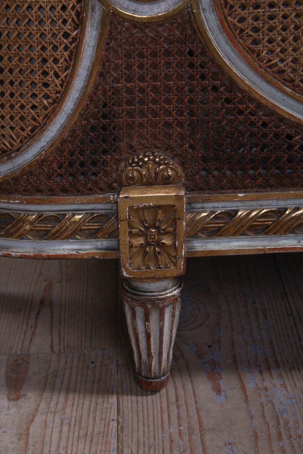 A Louis XVI style French corbeille bed featuring a carved giltwood frame, woven cane panels, fluted legs, and a rounded footboard. View VII