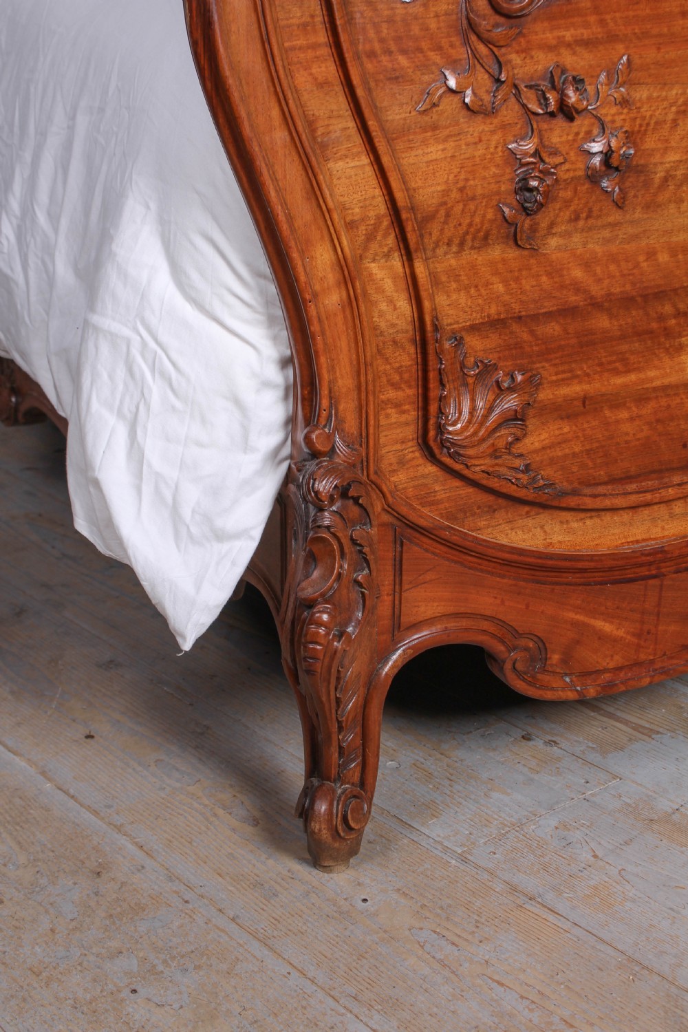 A French Louis XV style carved timber bedroom suite featuring a king-size bedstead, matching bedside cabinet, and three-door mirrored armoire. View VII