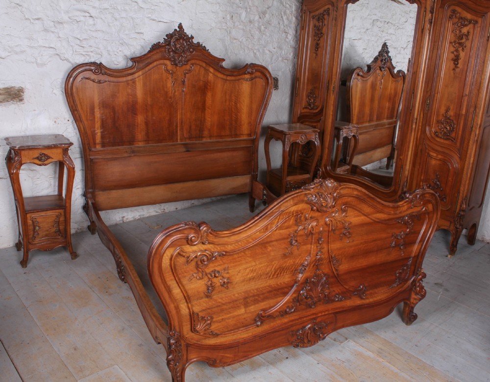 A French Louis XV style carved timber bedroom suite featuring a king-size bedstead, matching bedside cabinet, and three-door mirrored armoire. View VIII