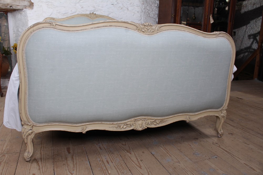 A Louis XV style king-size bed frame featuring a carved cream painted timber surround, upholstered headboard and footboard in pale blue fabric, resting on cabriole legs. View V
