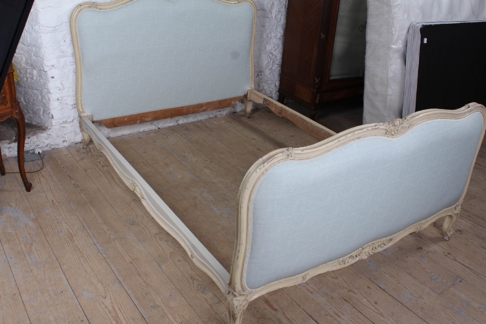 A Louis XV style king-size bed frame featuring a carved cream painted timber surround, upholstered headboard and footboard in pale blue fabric, resting on cabriole legs. View VI
