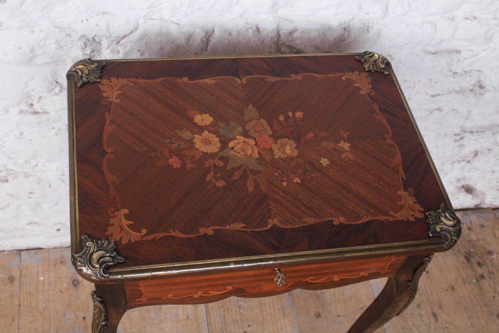 A French Louis XV style walnut side table featuring floral marquetry inlay, cabriole legs, and brass ormolu mounts. View II