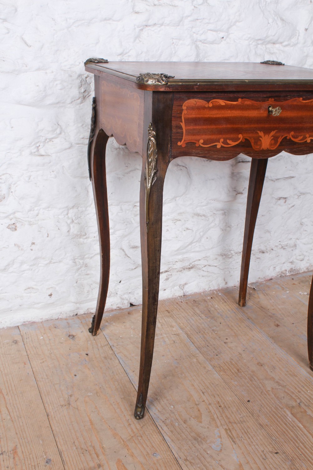 A French Louis XV style walnut side table featuring floral marquetry inlay, cabriole legs, and brass ormolu mounts. View IV