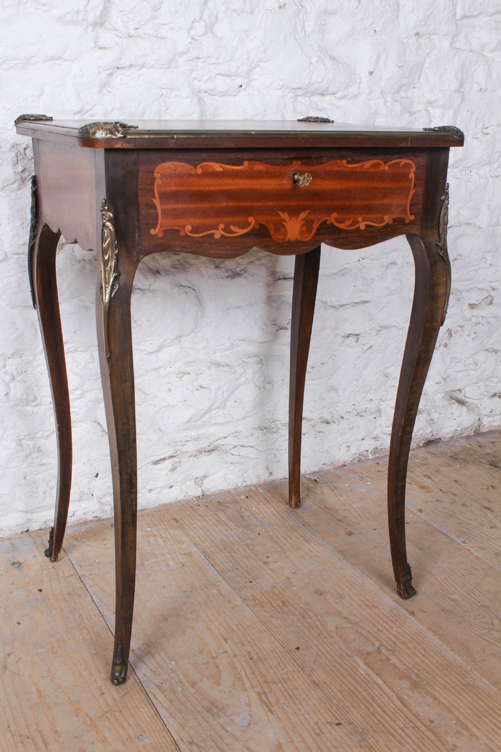 A French Louis XV style walnut side table featuring floral marquetry inlay, cabriole legs, and brass ormolu mounts. View VI